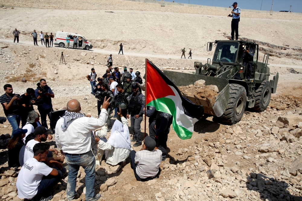 REPRESENTATIVE IMAGE: Palestinians gather in front of an Israeli bulldozer at Palestinian Bedouin village of Khan al-Ahmar in the occupied West Bank, September 14, 2018. Reuters/Mussa Qawasma