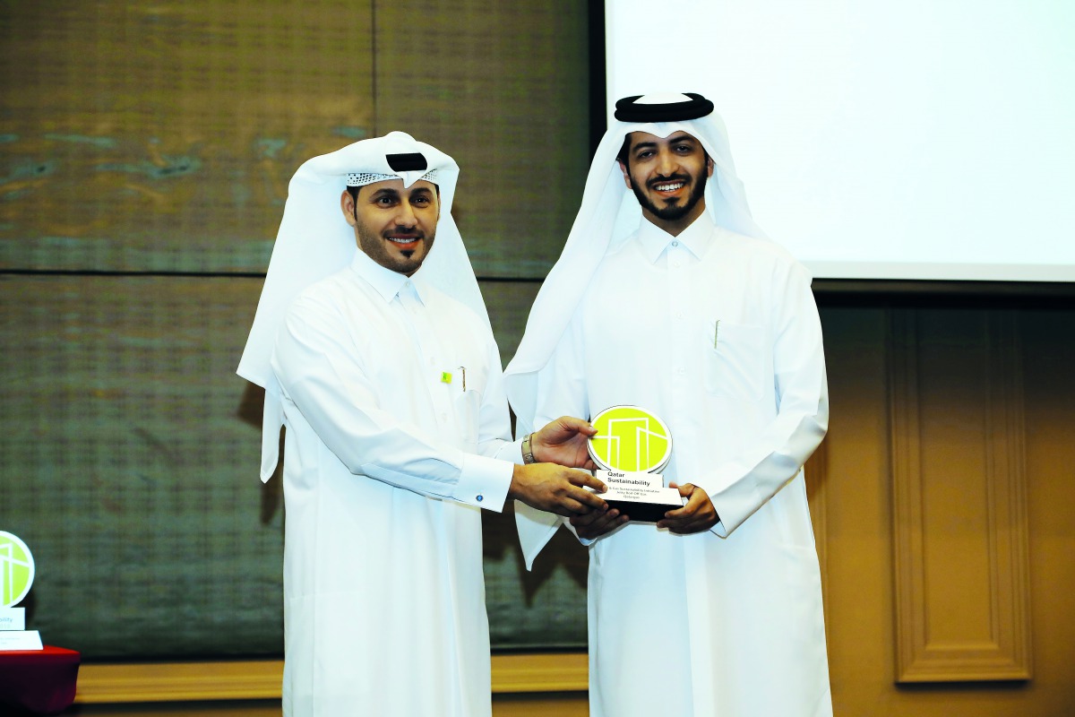 Hilal Saad Al Mohannadi (right), Head of Environment Regulatory and Compliance at Qatargas, receiving the award from Meshal Al Shamari, Director of Qatar Green Building Council.