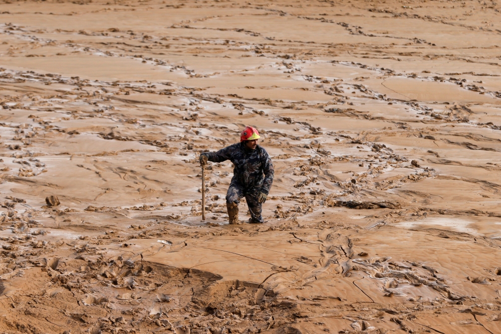 A civil defense member looks for missing persons after rain storms unleashed flash floods, in Madaba city, near Amman, Jordan, November 10, 2018. REUTERS/Muhammad Hamed 