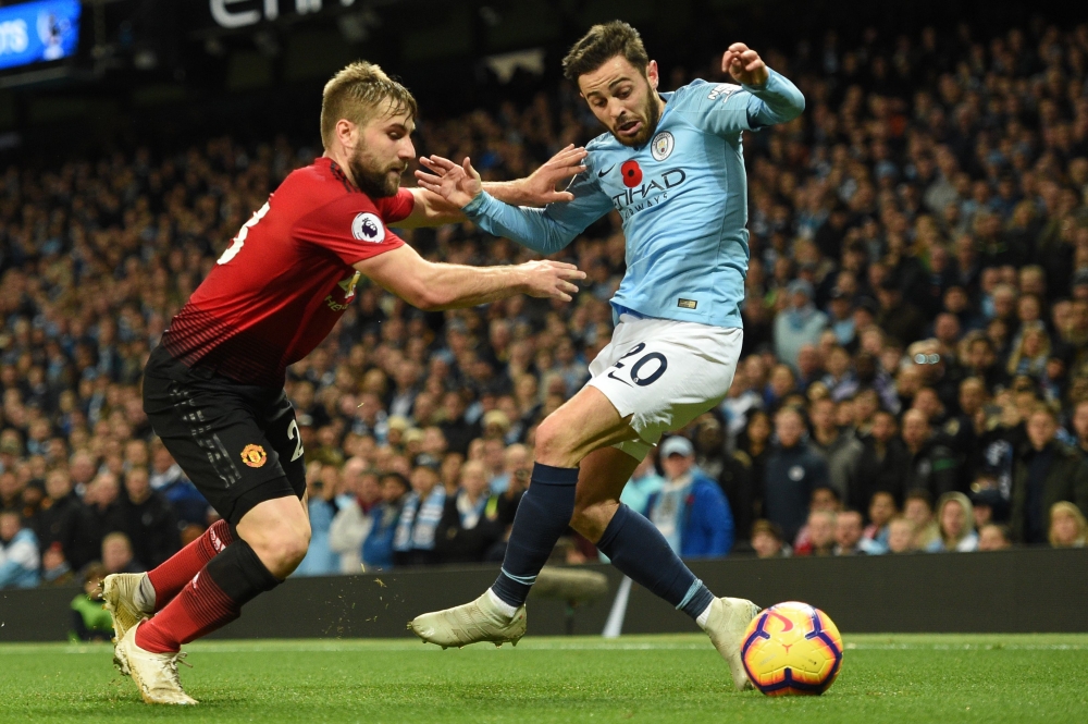 Manchester United's English defender Luke Shaw (L) vies with Manchester City's Portuguese midfielder Bernardo Silva during the English Premier League football match between Manchester City and Manchester United at the Etihad Stadium in Manchester, north w