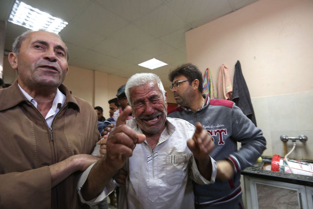 The relative of a man killed in an Israeli air stike across the Gaza Strip reacts after identifying his body at a hospital morgue in Beit Lahya on November 13, 2018. AFP /Mahmud Hams
 