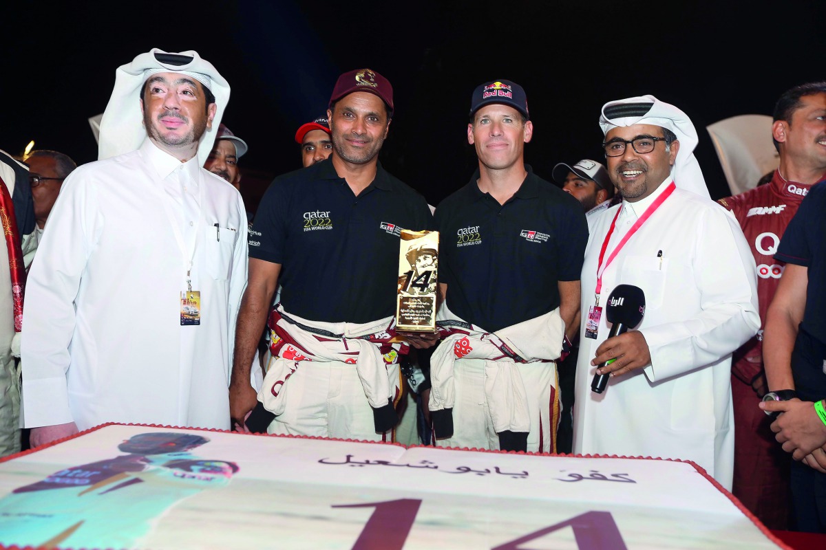 Manateq CEO Fahad Al Kaabi (left) and Qatar Motor and Motorcycle Federation (QMMF) President Abdulrahman Al Mannai (right) pose for a photograph with Qatari driver Nasser Saleh Al Attiyah and his navigator Matthieu Baumel after presenting the 14-time regi