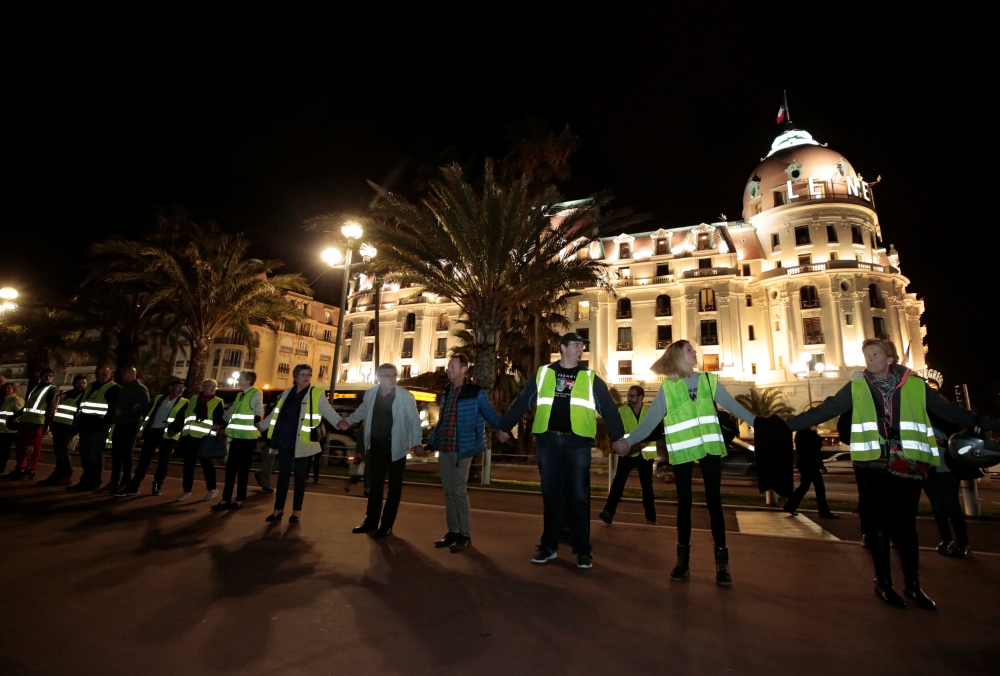 Protesters wearing yellow vests, a symbol of a French drivers' protest against higher fuel prices, attend a demonstration in front of the Negresco Hotel ahead of a nationwide protest, in Nice, France, November 15, 2018. REUTERS/Eric Gaillard