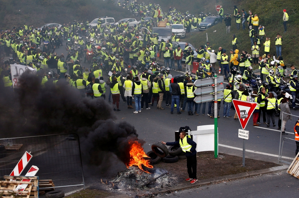 Protesters wearing yellow vests, a symbol of a French drivers' protest against higher fuel prices, attend a demonstration at the entrance of a shopping center in Nantes, France, November 17, 2018. REUTERS/Stephane Mahe