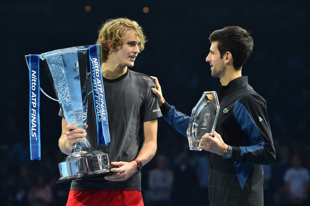 Germany's Alexander Zverev (L) chats to Serbia's Novak Djokovic as they pose with their trophies after the men's singles final match on day eight of the ATP World Tour Finals tennis tournament at the O2 Arena in London on November 18, 2018. AFP / Glyn KIR