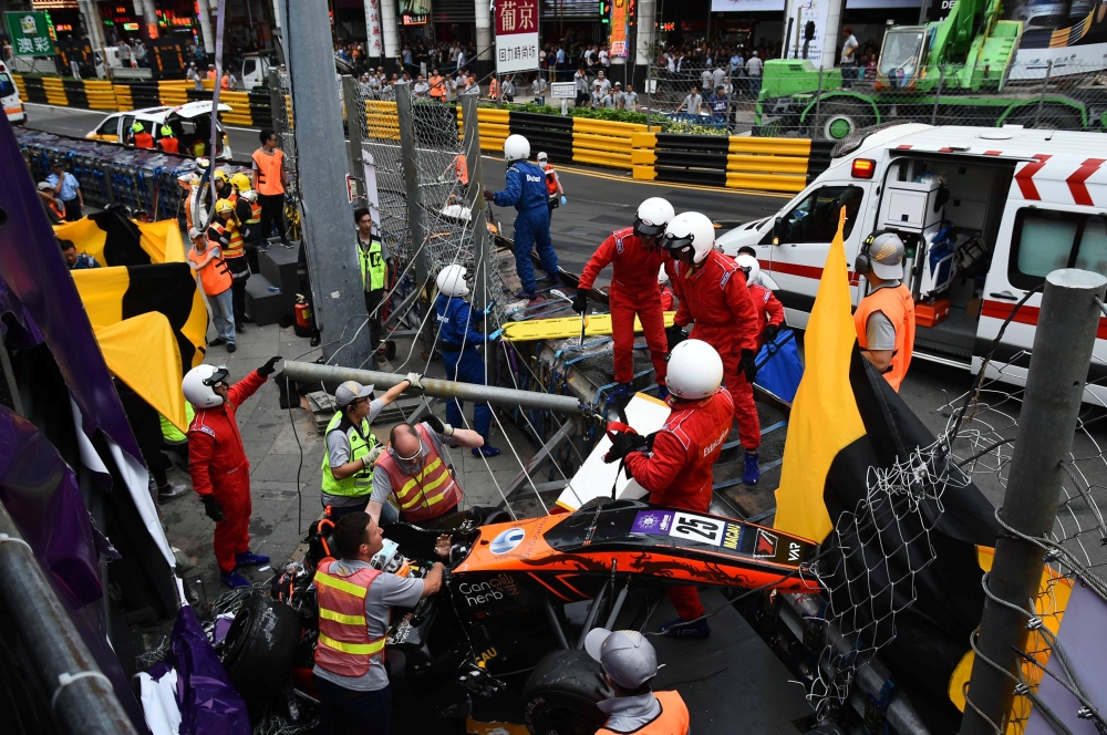 Race personnel and pit crew are seen at the accident site after Sophia Floersch, a German driver of Van Amersfoort Racing flew over the barriers and crashed into a photographers' bunker at high speed, during a Formula Three race at the Macau Grand Prix, i