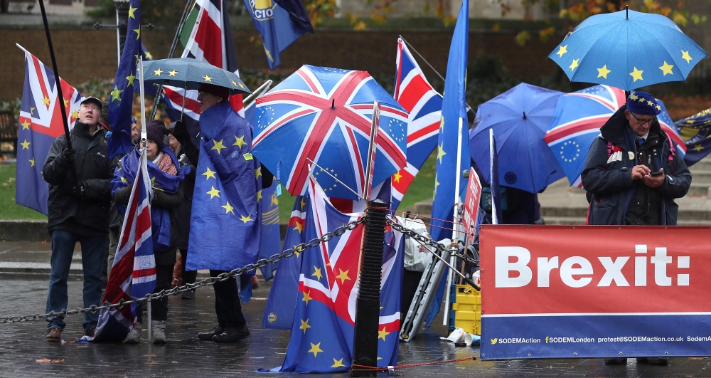 Pro-Eropean Union (EU), anti-Brexit demonstrators wave European Union (EU) and Union flags as they protest outside of the Houses of Parliament in central London on November 20, 2018.   AFP / Daniel LEAL-OLIVAS