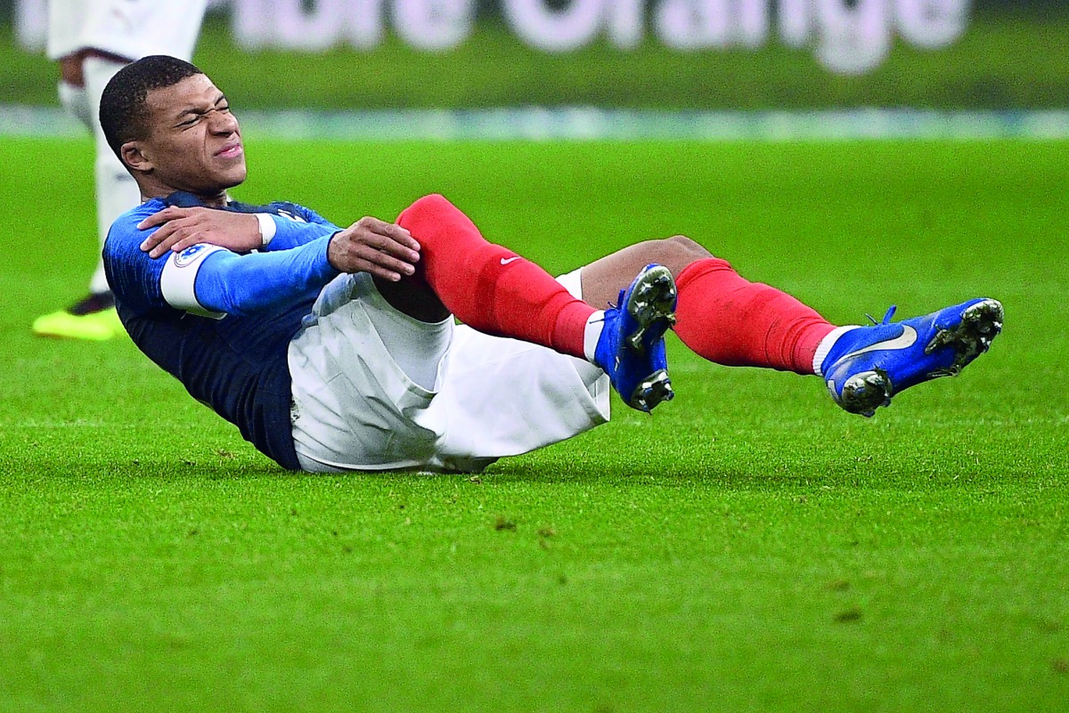 France's midfielder Kylian Mbappe (C) reacts after getting injured during the friendly football match France vs Uruguay, on November 20, 2018 at the Stade de France in Saint-Denis, outside Paris. AFP / Franck Fife