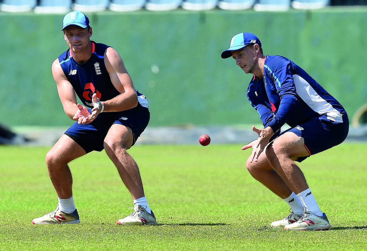 England's captain Joe Root (R) takes a catch as Jos Buttler looks on during a practice session at the Sinhalese Sports Club (SSC) Ground in Colombo on November 21, 2018.  AFP / Ishara S Kodikara
