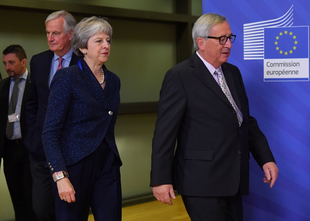 British Prime Minister Theresa May (C) is welcomed by European Commission President Jean-Claude Juncker (R) and Brexit Chief negotiator Michel Barnier (2L) at the European Commission in Brussels on November 24, 2018.   AFP / Emmanuel DUNAND
