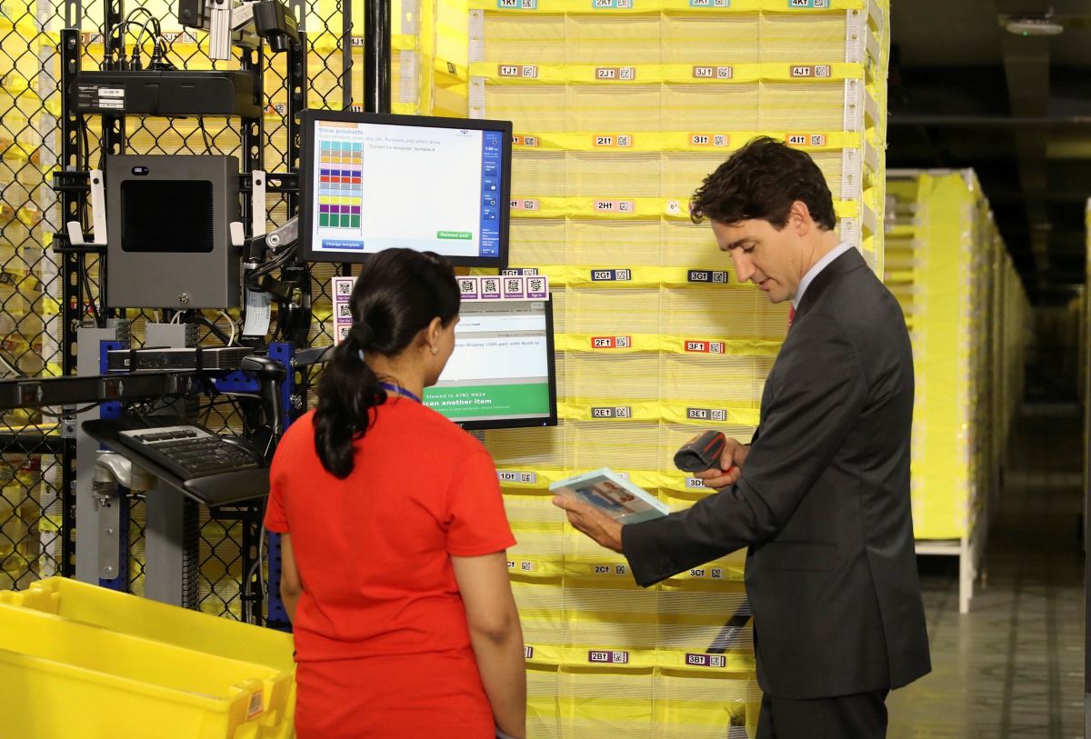 Canada Prime Minister Justin Trudeau scans merchandise with an employee during a tour of the Amazon Fulfillment Centre in Brampton, Ontario, Canada, October 20, 2016. Reuters/Fred Thornhill