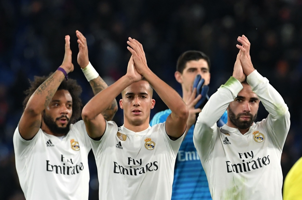 Real Madrid's Brazilian defender Marcelo, Real Madrid's Spanish midfielder Lucas Vazquez, Real Madrid's Belgian goalkeeper Thibaut Courtois (Rear) and Real Madrid's Spanish defender Dani Carvajal acknowledge the public at the end of the UEFA Champions Lea