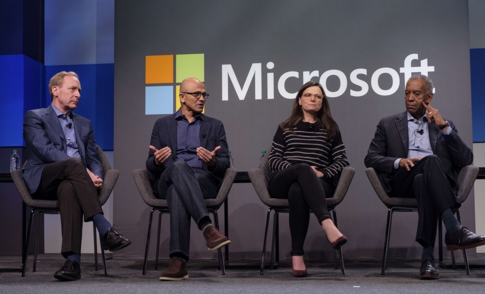 Microsoft CEO Satya Nadella, second from left, answers a shareholders question while President Brad Smith, CFO Amy Hood and Board Chairman John Thompson listen during the Microsoft Annual Shareholders Meeting at the Meydenbauer Center on November 28, 2018