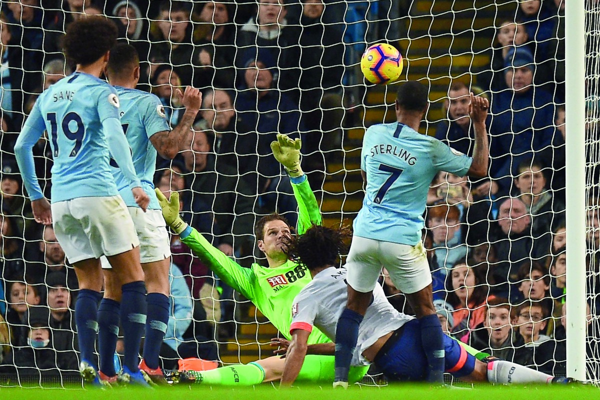 Manchester City's English midfielder Raheem Sterling (R) scores their second goal for 2-1 past Bournemouth's Bosnian-Herzegovinian goalkeeper Asmir Begovic (C) during the English Premier League football match between Manchester City and Bournemouth at the