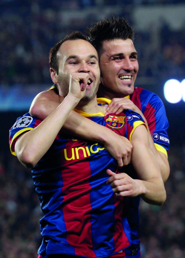 Barcelona’s Iniesta celebrates with team-mate David Villa after scoring a goal in this file photo.