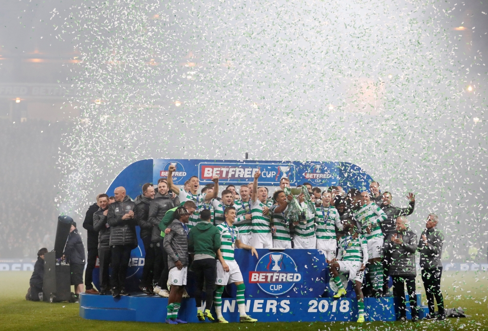 Celtic players celebrate with the trophy after winning the final REUTERS/Russell Cheyne