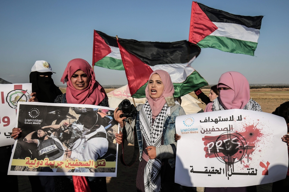 Palestinian Journalists take part in a protest against the killing of fellow journalist Yasser Murtaja near the Israel-Gaza border in Rafah in the southern Gaza Strip on April 8, 2018. AFP/Said Khatib