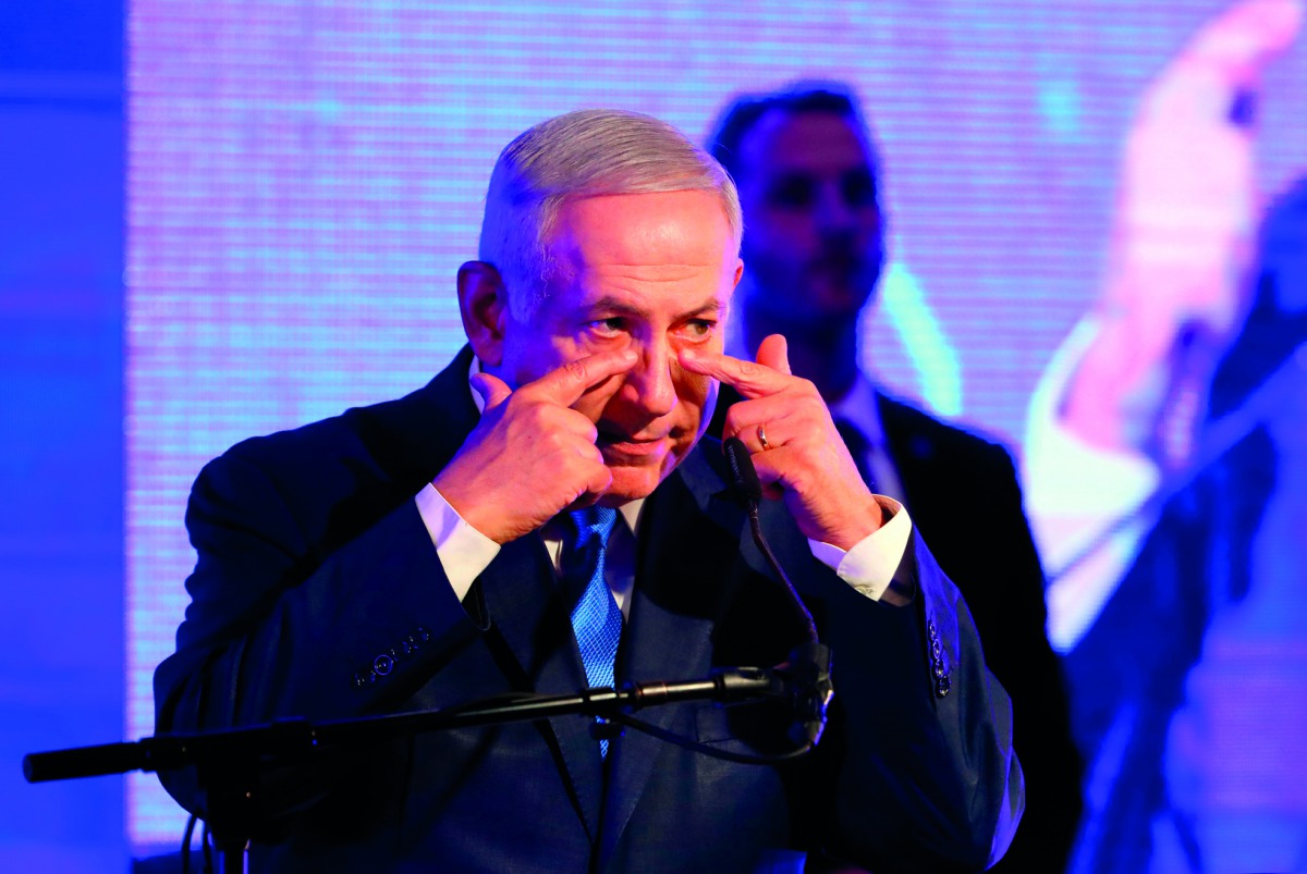 Israeli Prime Minister Benjamin Netanyahu gestures towards his eyes while delivering a speech before lighting candles during the start of Hanukkah, the Jewish festival of lights, in Ramat Gan in the suburbs of the Mediterranean coastal city of Tel Aviv on