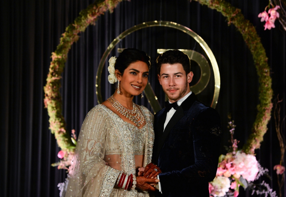 Indian Bollywood actress Priyanka Chopra (L) and US musician Nick Jonas, who were recently married, pose for a photograph during a reception in New Delhi on December 4, 2018. AFP / SAJJAD HUSSAIN