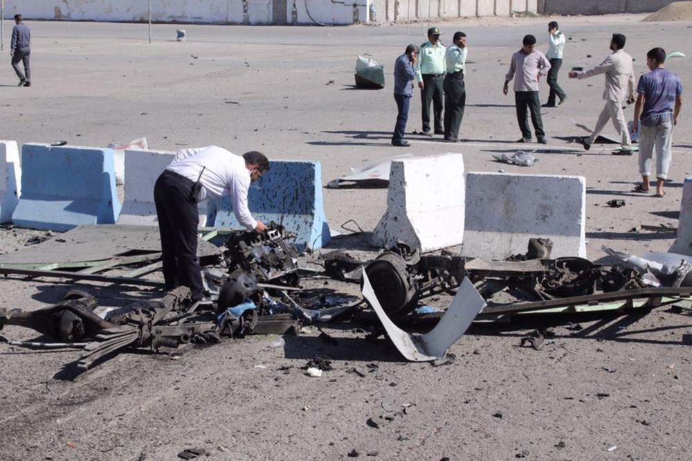 A policeman inspects the wreckage of a car bomb which exploded in front of a police station in the city of Chabahar, on December 06, 2018 in southern Iran. AFP / FARS NEWS AGENCY
