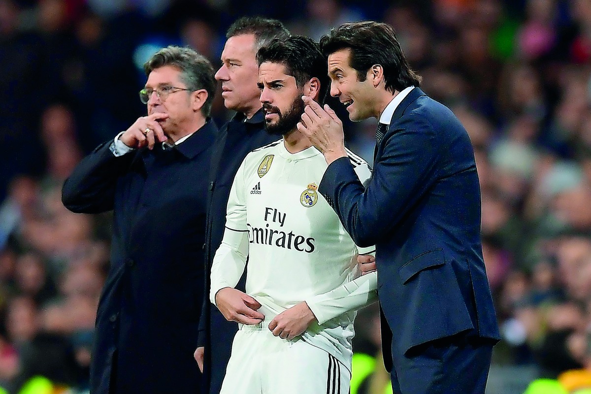 Real Madrid's Argentinian coach Santiago Solari speaks to Real Madrid's Spanish midfielder Isco before he enters into the pitch during the Spanish league football match between Real Madrid and Valencia at the Santiago Bernabeu stadium in Madrid on Decembe