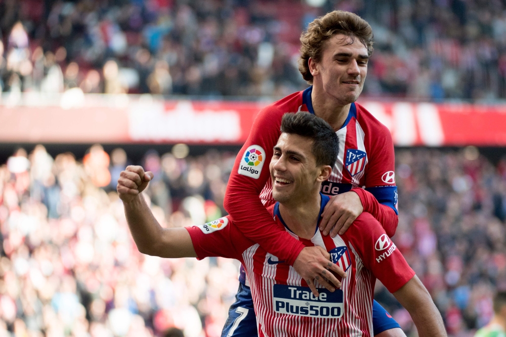 Atletico Madrid's Spanish midfielder Rodrigo celebrates with teammate Atletico Madrid's French forward Antoine Griezmann after scoring a goal during the Spanish league football match between Club Atletico de Madrid and Deportivo Alaves at the Wanda Metrop