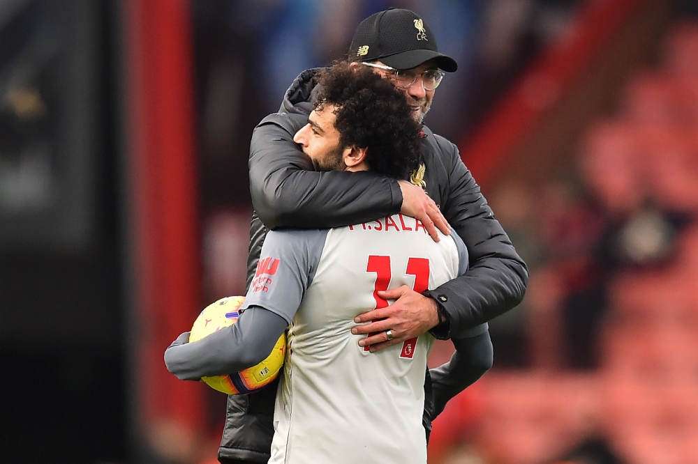 Liverpool's Egyptian midfielder Mohamed Salah (L) holding the match-ball for scoring a hat-trick is embraced by Liverpool's German manager Jurgen Klopp (R) on the pitch after the English Premier League football match between Bournemouth and Liverpool at t
