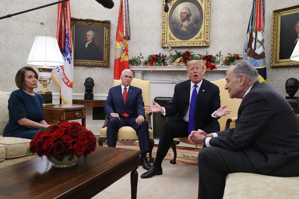 U.S. President Donald Trump (2R) argues about border security with Senate Minority Leader Chuck Schumer (D-NY) (R) and House Minority Leader Nancy Pelosi (D-CA) as Vice President Mike Pence sits nearby in the Oval Office on December 11, 2018 in Washington