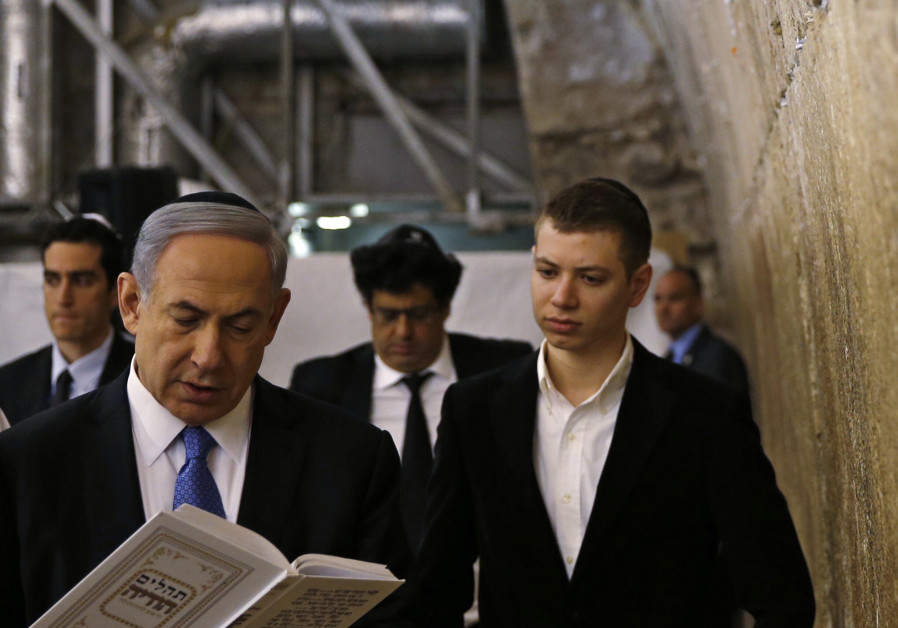 Yair Netanyahu observes his father Israeli Prime Minister Benjamin Netanyahu reading a prayer at the Western Wall in Jerusalem' Old City. (Ronen Zvulun / Reuters)
