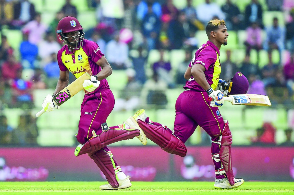 West Indies cricketer Keemo Paul (L) and Nicholas Pooran (R) run between the wickets during the first Twenty20 (T20) cricket match between Bangladesh and West Indies at the Sylhet International Cricket Stadium in Sylhet on December 17, 2018. AFP / Munir U