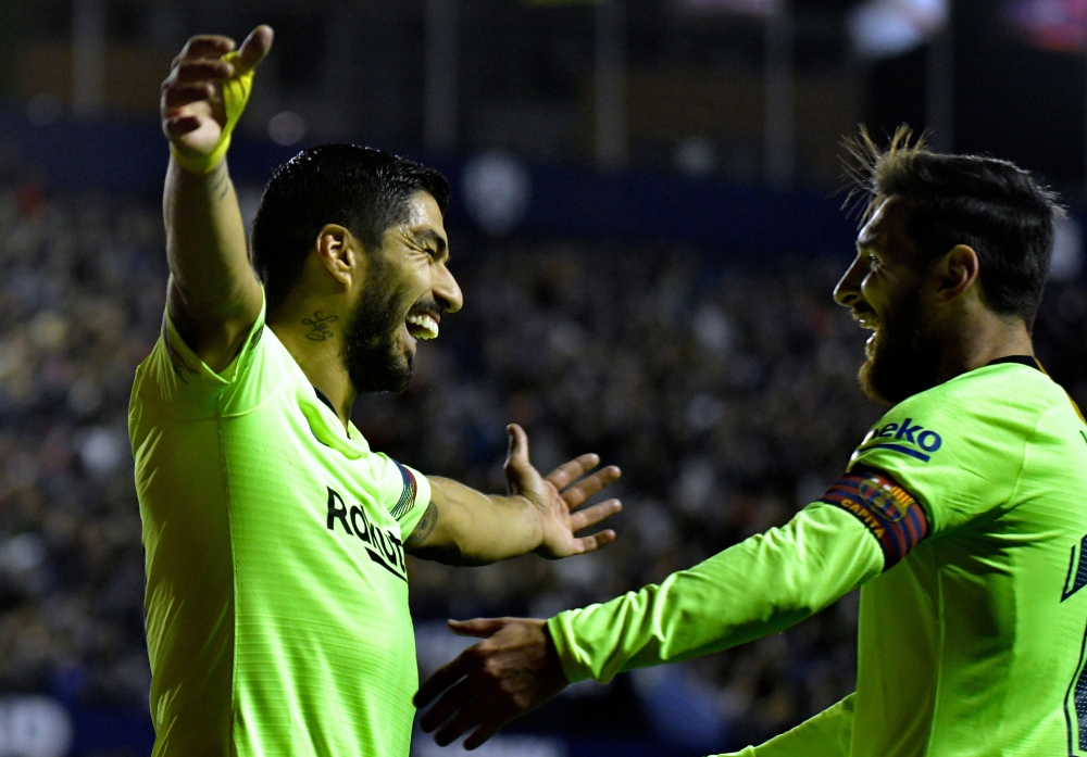 Barcelona's Uruguayan forward Luis Suarez (L) celebrates a goal with Barcelona's Argentinian forward Lionel Messi during the Spanish League football match between Levante and Barcelona at the Ciutat de Valencia stadium in Valencia on December 16, 2018. / 