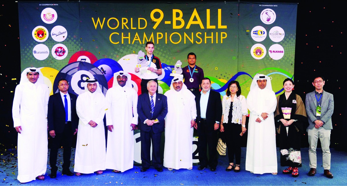 The champion, Joshua Filler (rear, centre) and runner-up Carlo Biado, pose for a photograph with the officials of Qatar Billiard and Snooker Federation and World Pool Billiard Association at the conclusion  of the 2018 World 9-Ball Championship at the Al 