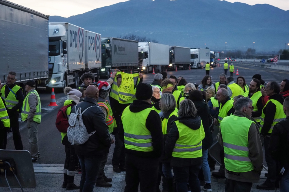 Yellow vest (Gilet jaune) protestors gather and block the A9 highway toll of Le Boulou, southern France on December 21, 2018, during a demonstration against rising oil prices and living costs. / AFP / Raymond ROIG 