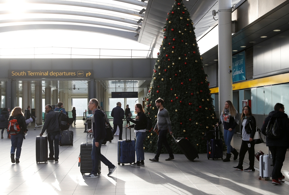Passengers walk with suitcases in Gatwick Airport, in Crawley, Britain, December 22, 2018. REUTERS/Peter Nicholls