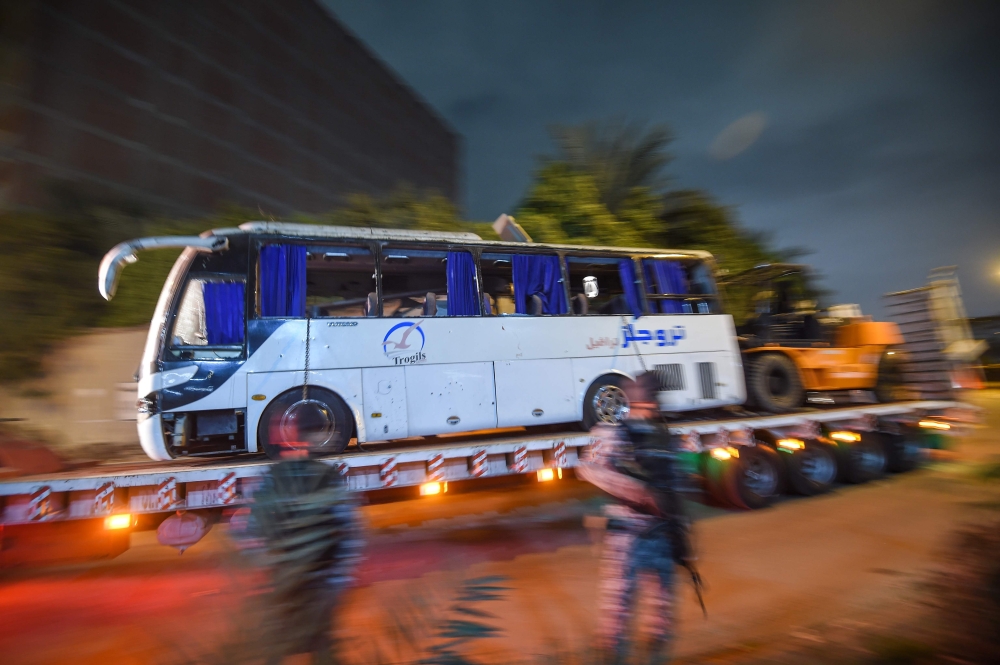 This picture taken on December 28, 2018 shows a tourist bus which was attacked being towed away from the scene, in Giza province south of the Egyptian capital Cairo. AFP / Mohamed el-Shahed