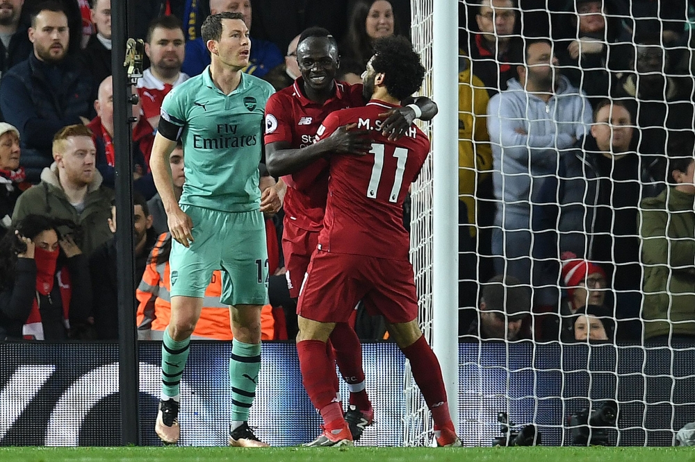 Liverpool's Senegalese striker Sadio Mane (C) celebrates scoring his team's third goal with Liverpool's Egyptian midfielder Mohamed Salah (R) during the English Premier League football match between Liverpool and Arsenal at Anfield in Liverpool, north wes
