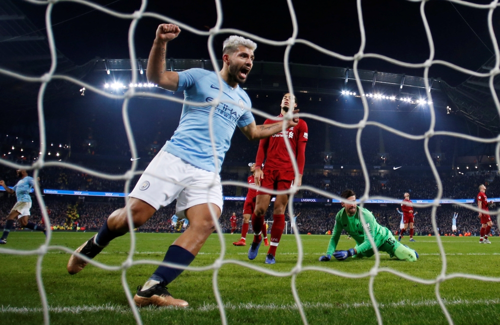 Manchester City's Sergio Aguero celebrates their second goal scored by Leroy Sane (not pictured) as Liverpool's Alisson and Virgil van Dijk look dejected REUTERS/Phil Noble