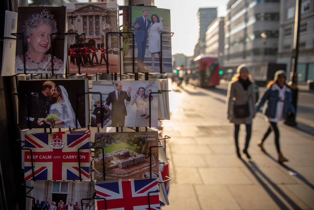 Pedestrians walk past souvenirs, including postcards depicting members of Britain's Royal Family in central London on January 4, 2019. (AFP / NIKLAS HALLE'N)