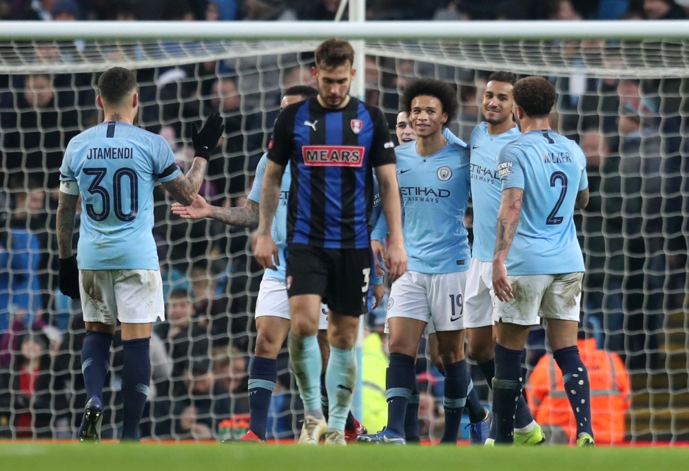 Manchester City's Leroy Sane celebrates scoring their seventh goal with team mates as Rotherham United's Joe Mattock looks dejected REUTERS/Jon Super
