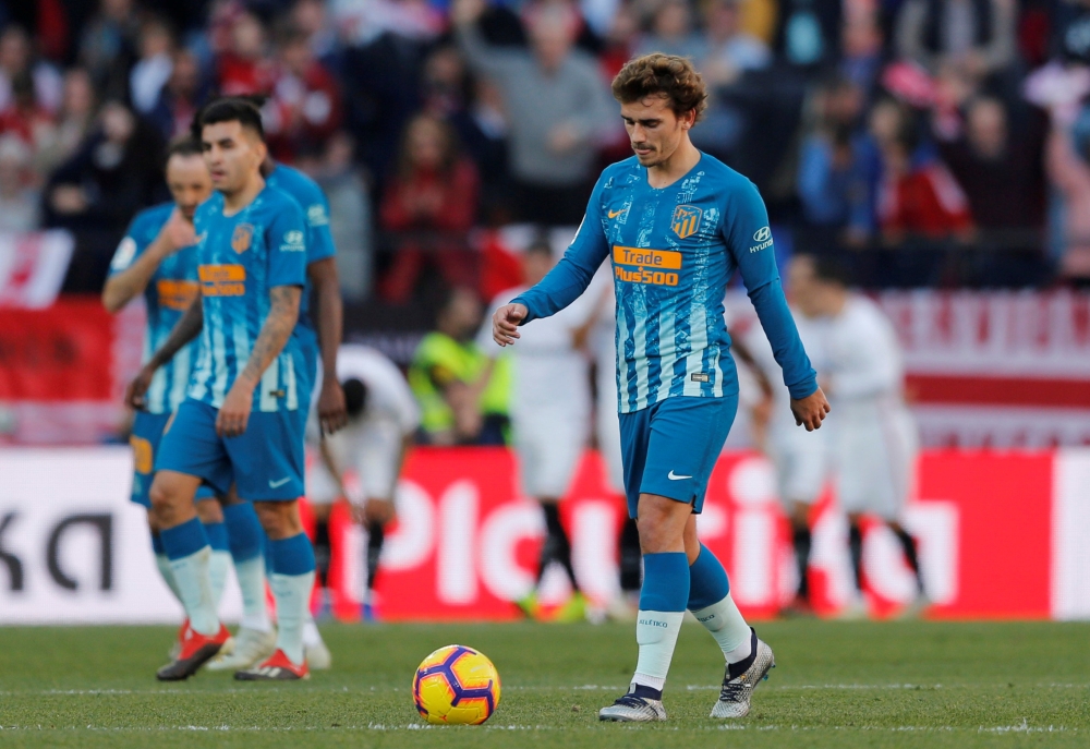 Atletico Madrid's Antoine Griezmann and team mates look dejected after conceding their first goal scored by Sevilla's Wissam Ben Yedder (not pictured) REUTERS/Marcelo Del Pozo