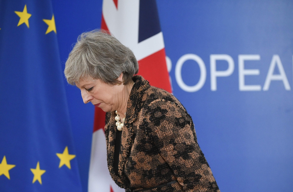 (FILES) In this file photo taken on December 14, 2018 Britain's Prime Minister Theresa May leaves after speaking during a press conference on December 14, 2018 in Brussels during the second day of a European Summit aimed at discussing the Brexit deal, the