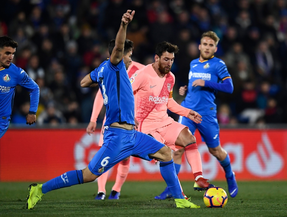 Barcelona's Argentinian forward Lionel Messi (C) vies with Getafe's Uruguayan defender Leandro Cabrera (L) during the Spanish League football match between Getafe CF and FC Barcelona at the Col. Alfonso Perez stadium in Getafe on January 6, 2019. / AFP / 