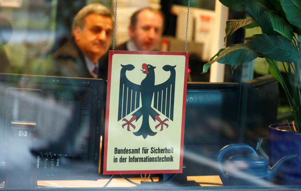 FILE PHOTO: Security personnel sits behind the bullet-proof window at the headquarters of Germany's BSI national cyber defence body in Bonn, Germany, January 4, 2019, after personal data and documents of German politicians and public figures have been pub