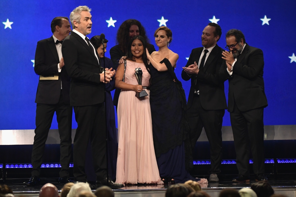 (L-R) Nicolas Celis, Alfonso Cuaron, Yalitza Aparicio, Adam Gough, Marina De Tavira, Jeff Skoll, and Eugenio Caballero accept the Best Picture award for 'Roma' onstage during the 24th annual Critics' Choice Awards at Barker Hangar on January 13, 2019, in 