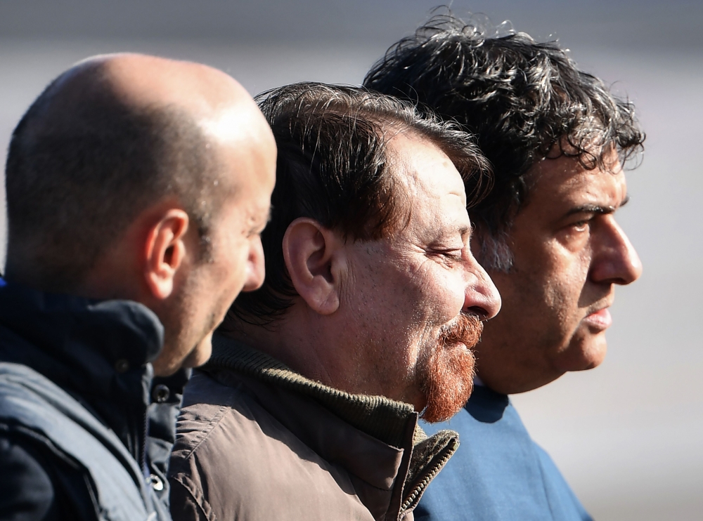 Italian former communist militant Cesare Battisti (C), wanted in Rome for four murders attributed to a far-left group in the 1970s, is escorted by Italian Police officers after stepping off a plane coming from Bolivia and chartered by Italian authorities,