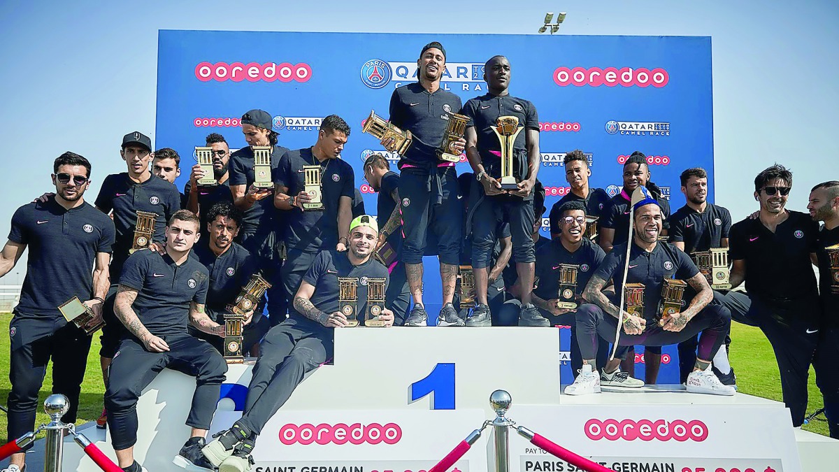 Paris Saint-Germain’s players and officials celebrate after taking part in a traditional camel race at the Al Shahaniya Racecourse in Doha, yesterday.  
