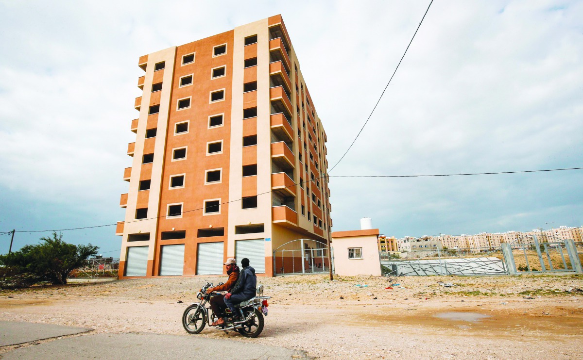 Palestinians ride a motorcycle past a newly-contsructed building funded by Iran to house Palestinian prisoners formerly held in Israeli jails, in Khan Yunis in the southern Gaza Strip on January 17, 2019.  AFP / Said Khatib