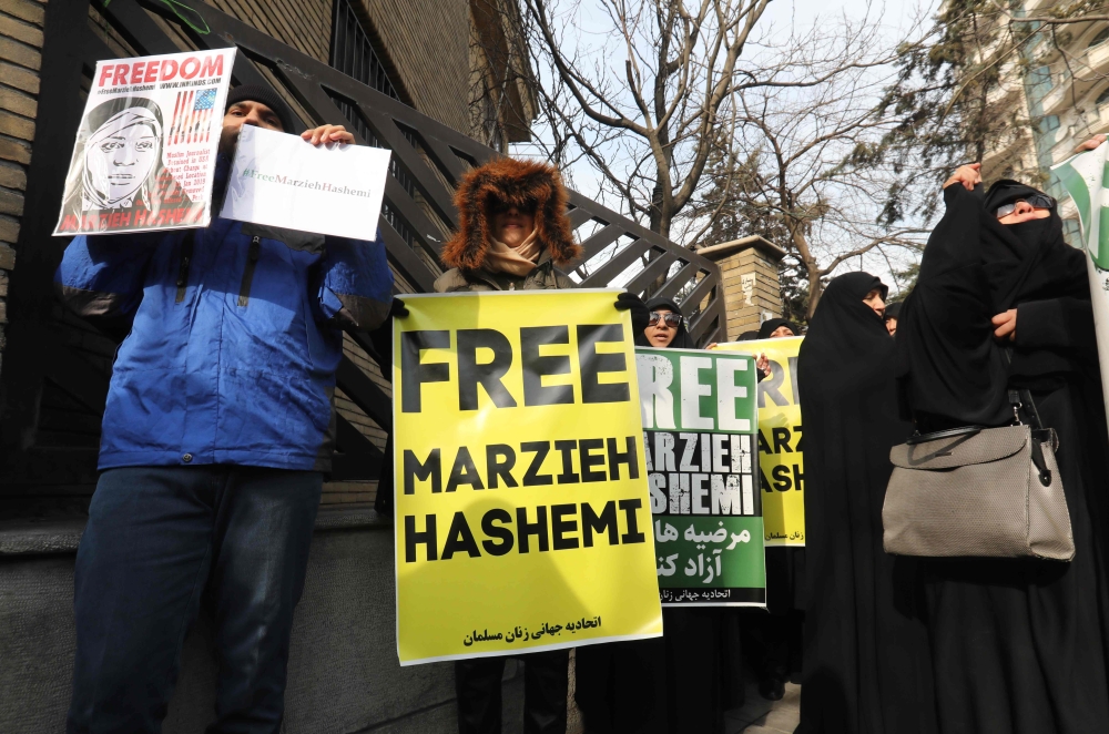 Iranians hold banners bearing messages that call for the release of US-born journalist Marzieh Hashemi, in front of the Swiss embassy in the capital Tehran on January 20, 2019. (AFP / ATTA KENARE)