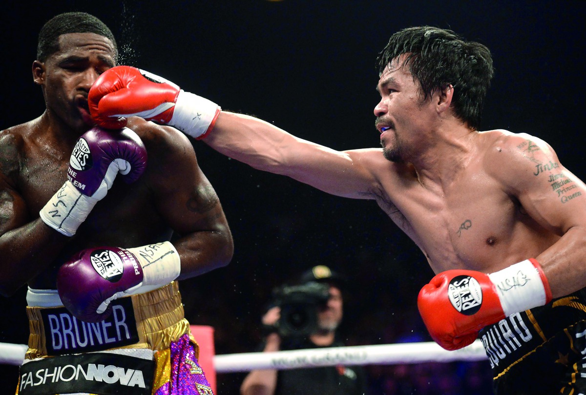 Manny Pacquiao (black trunks) and Adrien Broner (purple/gold trunks) box during a WBA welterweight world title boxing match at MGM Grand Garden Arena. Credit: Joe Camporeale-USA TODAY Sports