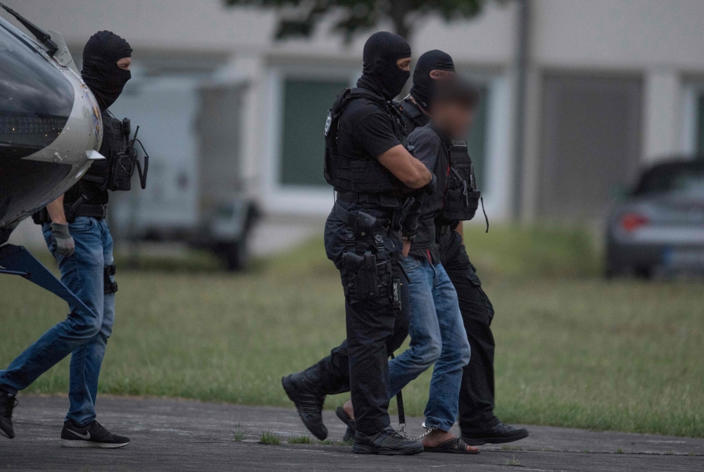 Police officers of a special unit escort Ali Bashar from a helicopter to the police headquarters in Wiesbaden western Germany, after he was flown back from Erbil to Germany AFP / dpa / Boris Roessler